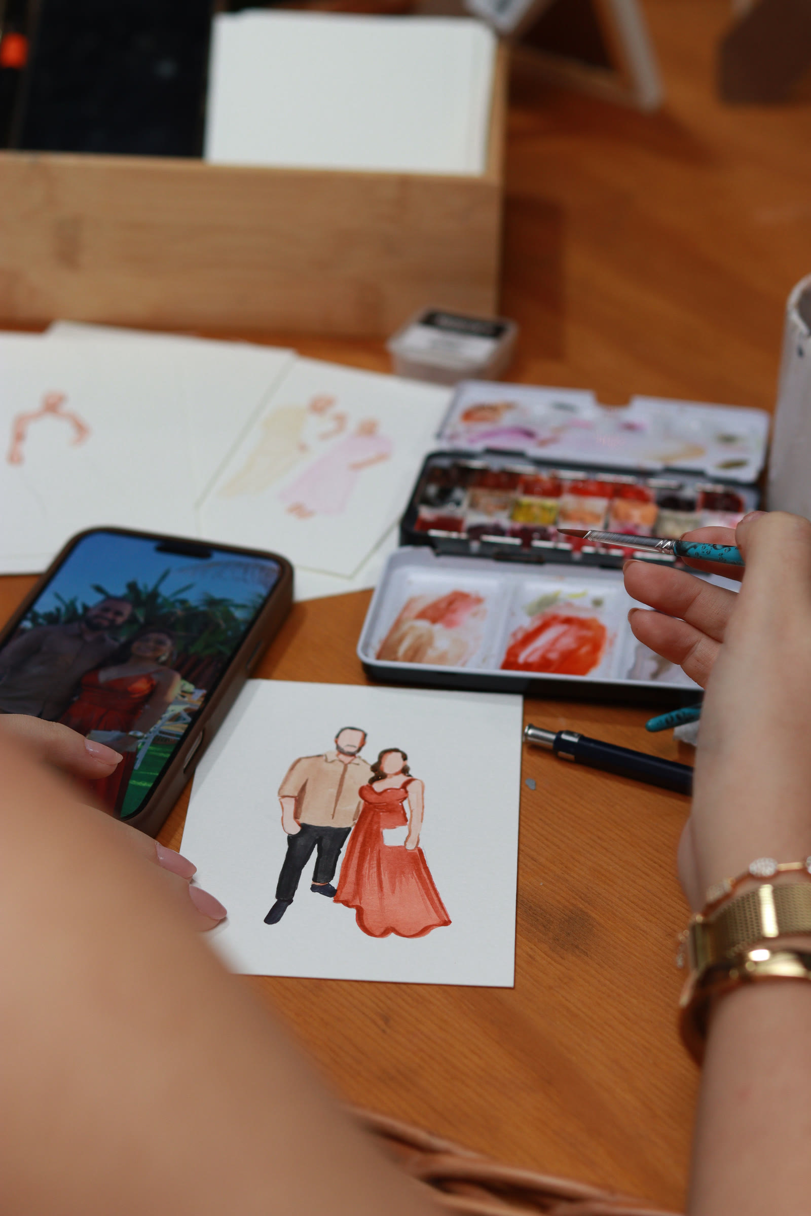 Foto no celular ao lado da aquarela pintada a partir dela
