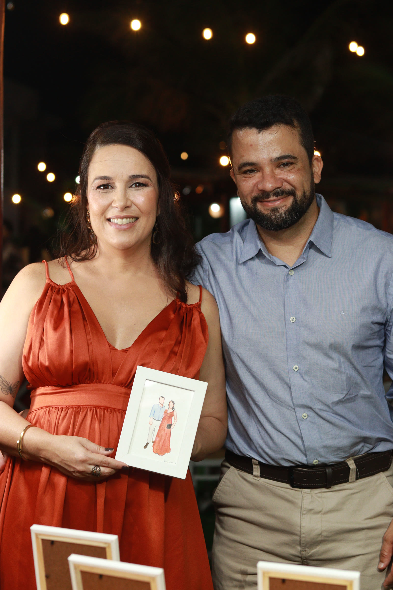 Casal segurando o retrato pintado ao vivo