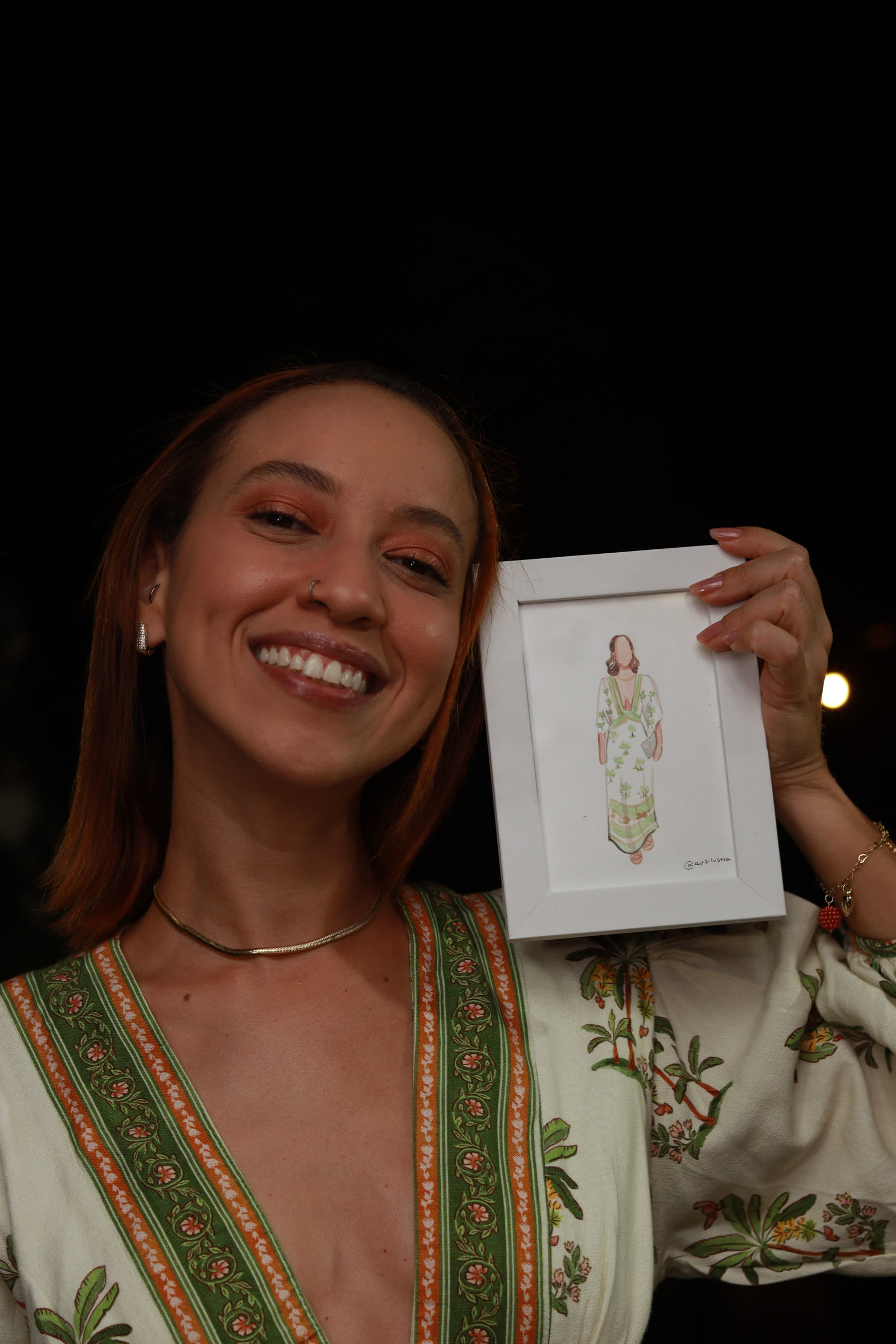 Convidada sorrindo segurando seu retrato emoldurado