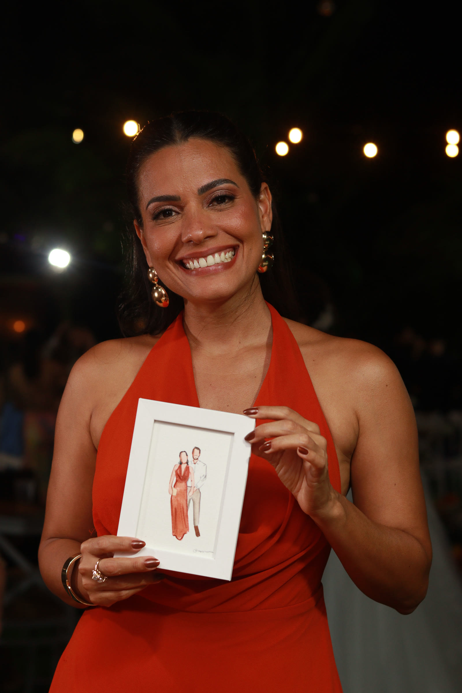 Convidada sorrindo com seu retrato emoldurado
