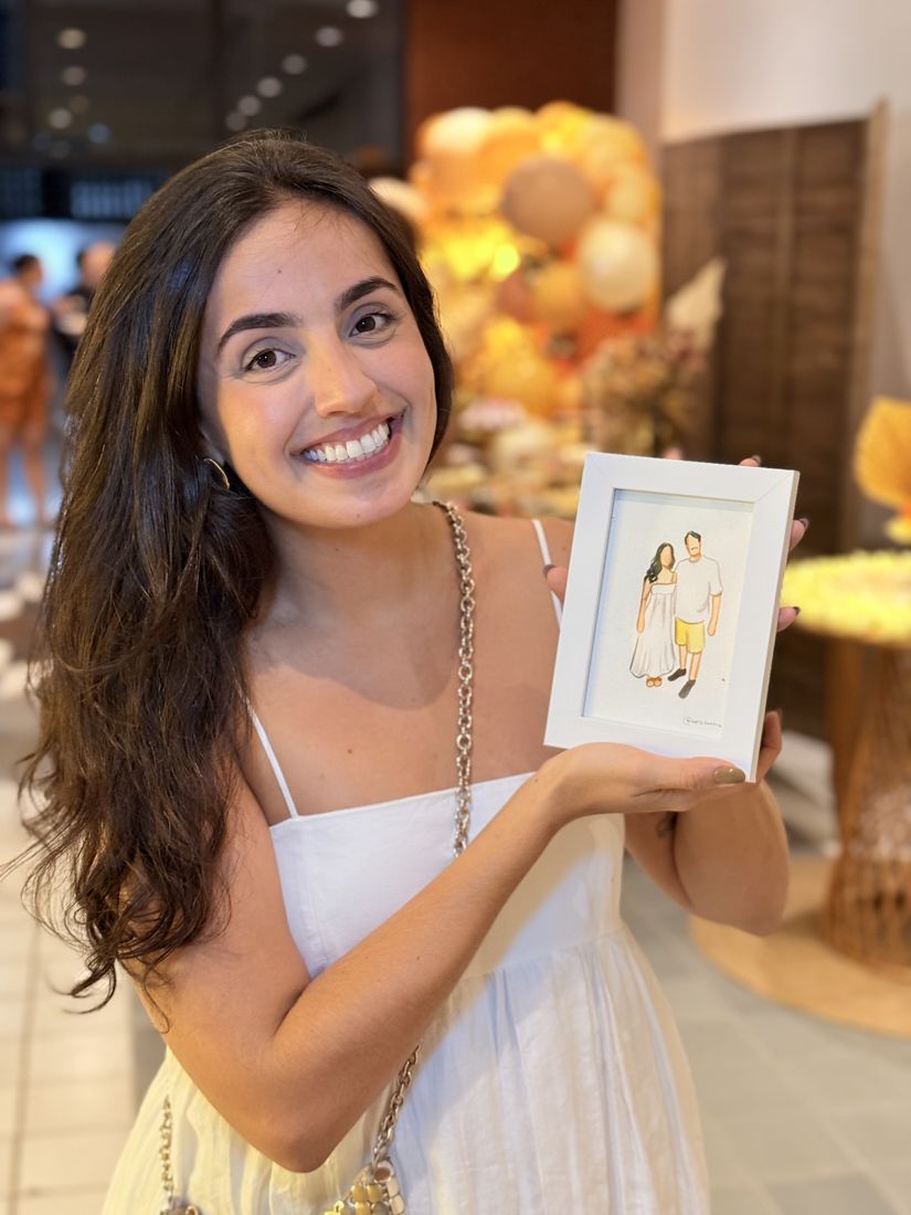 Convidada segurando seu retrato em aquarela