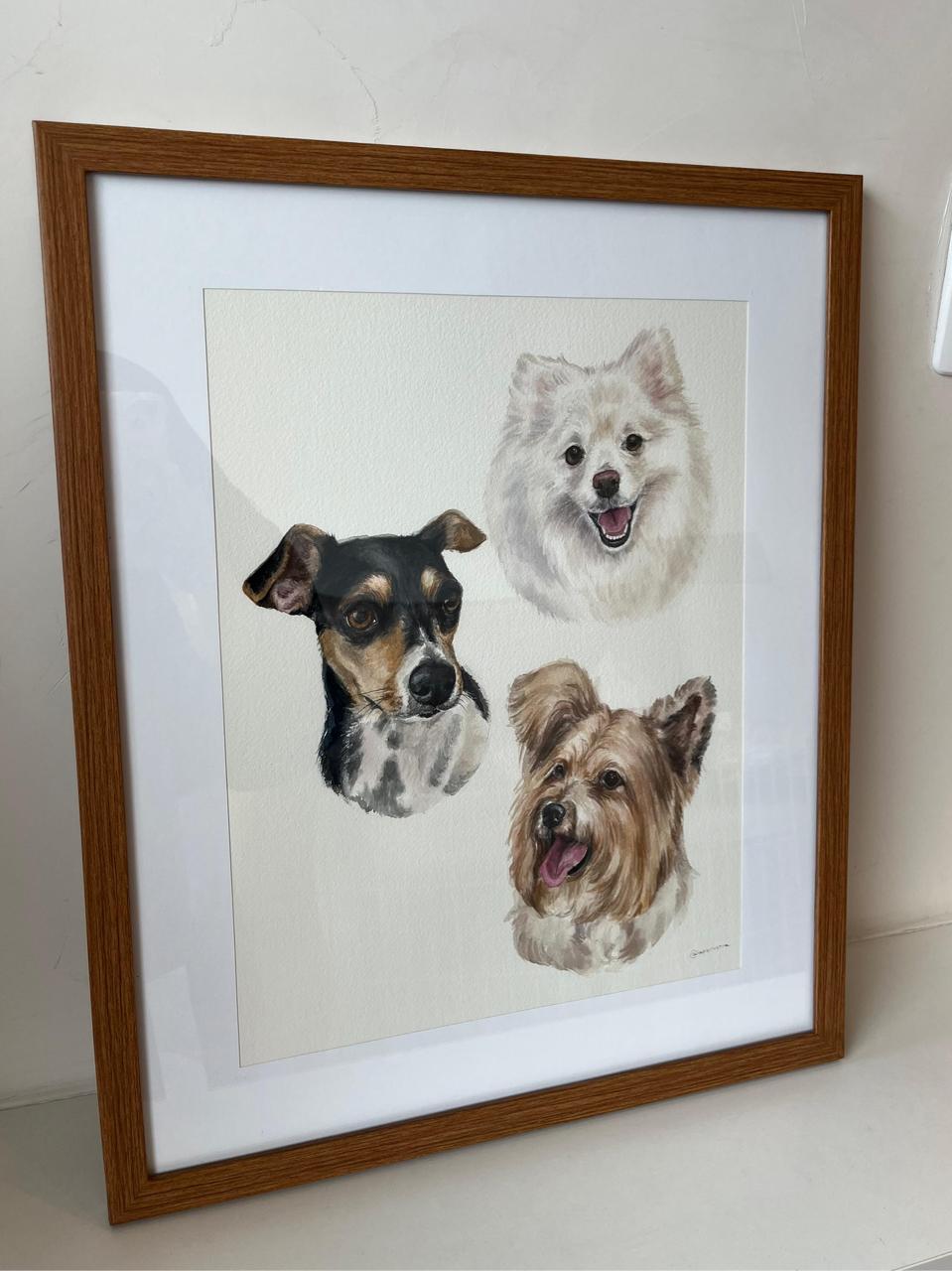 Aquarela com três cachorros na mesma folha, emoldurada em madeira clara