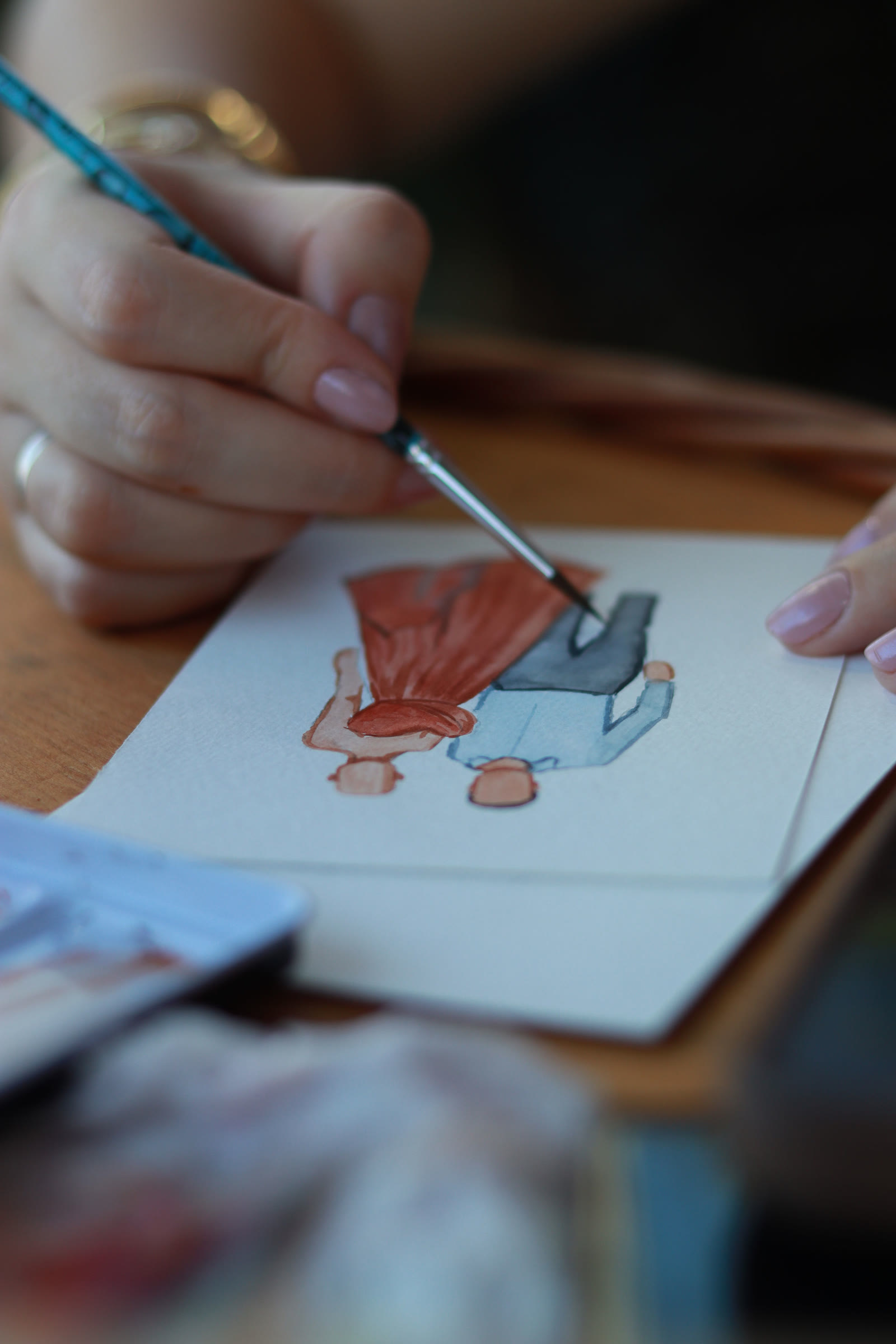 Pincel finalizando a aquarela de um casal