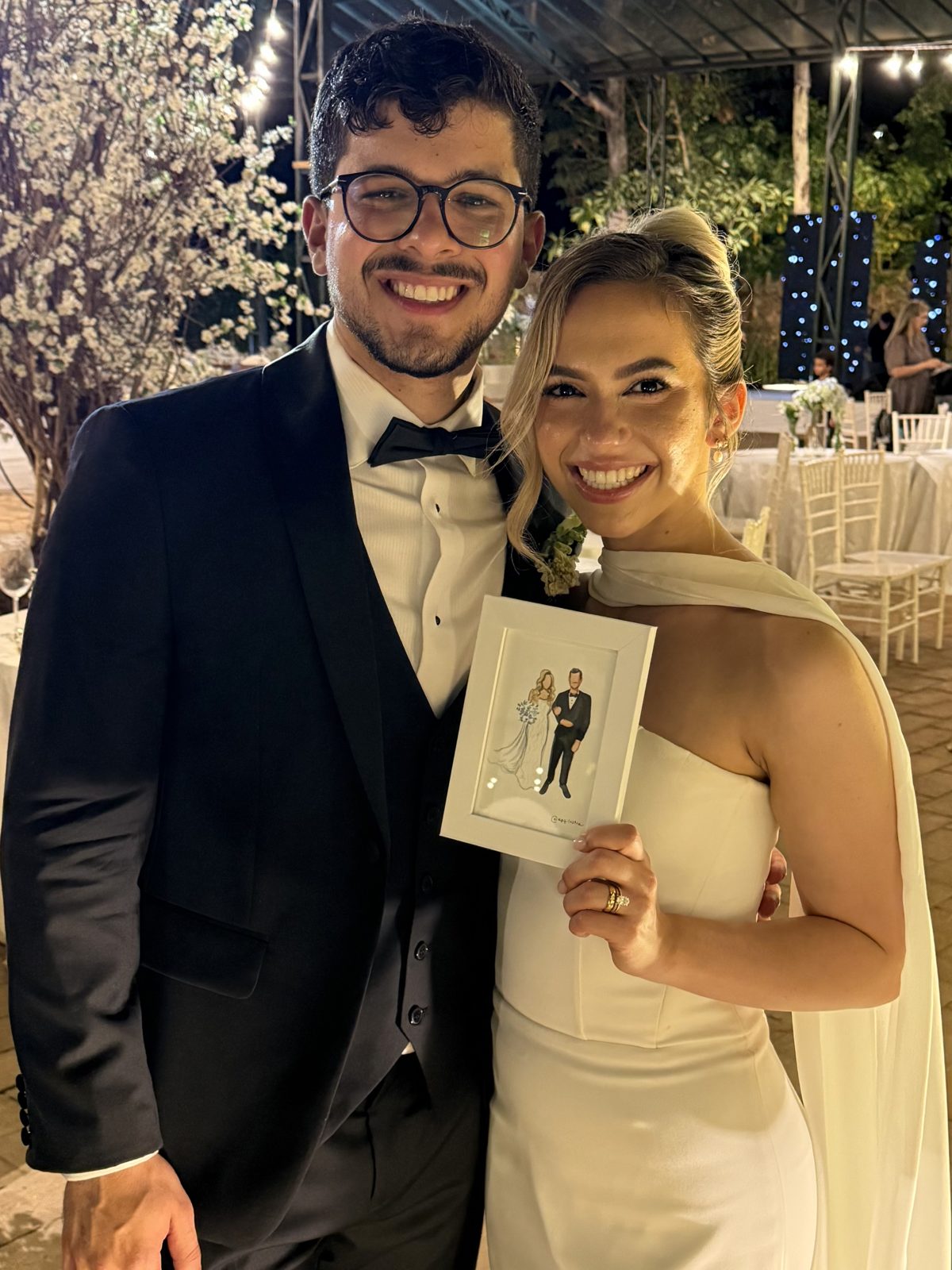Noivos segurando o retrato pintado ao vivo no casamento