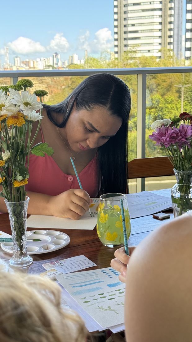 Aluna pintando com a cidade ao fundo