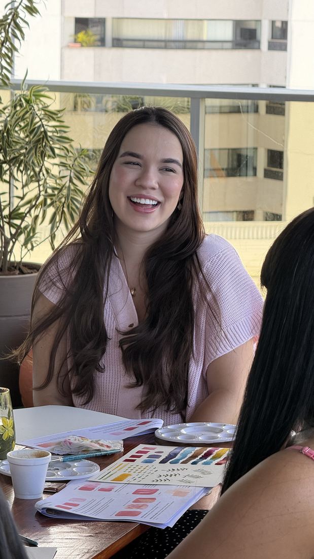 Aluna rindo na mesa do workshop